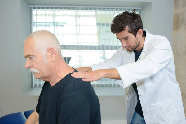 Fisioterapeuta haciendo masaje de espalda a su paciente en consultorio médico —  Fotos de Stock