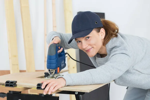 Mujer usando sierra para cortar madera mujer — Foto de Stock