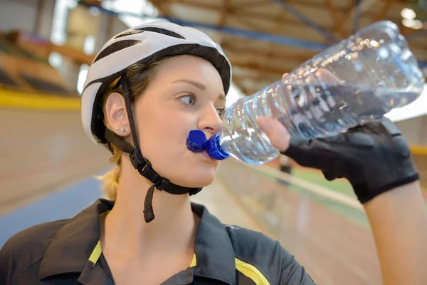 Ciclista feminino bebendo água depois de terminar um passeio divertido — Fotografia de Stock