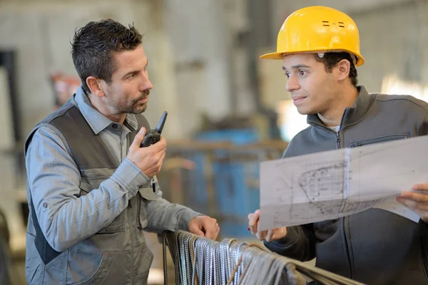 Ingenjör och arbetstagaren kontroll plan på byggarbetsplats — Stockfoto