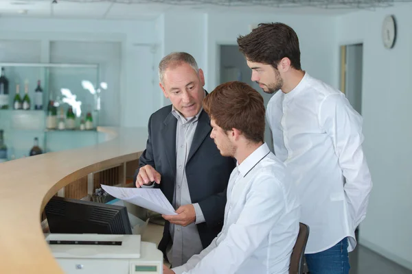 Gerente explicando algo para seu empregado em uma recepção — Fotografia de Stock