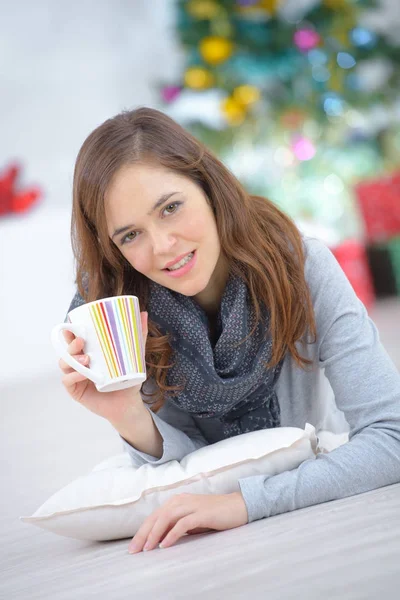 Mujer tendida en el suelo con una taza de café — Foto de Stock