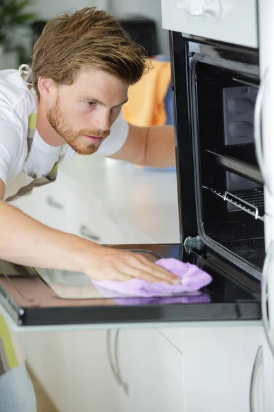 Homem forno de limpeza e limpeza — Fotografia de Stock