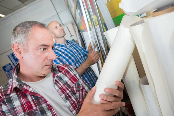 Printer worker choosing roll of paper — Stock Photo, Image