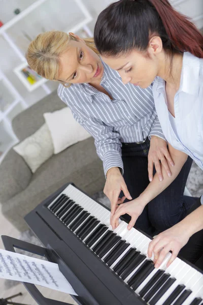 Experiente mão mestre piano feminino ajuda o aluno — Fotografia de Stock