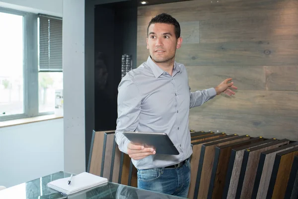 Homme d'affaires créatif pointant au mur dans le bureau — Photo