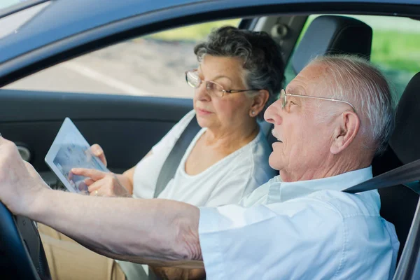 Pareja madura perdida dentro de un coche — Foto de Stock