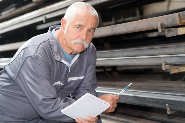 Man in de metaalindustrie magazijn producten controleren — Stockfoto