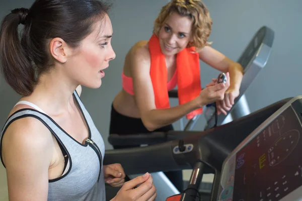 Dos amigos en el gimnasio haciendo ejercicio en las máquinas —  Fotos de Stock