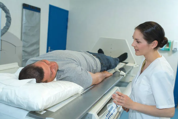 Paciente masculino listo para someterse a una resonancia magnética asistido por médicos —  Fotos de Stock