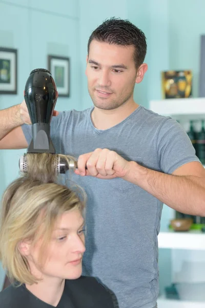 Cabeleireiro profissional secagem cabelo de seu cliente — Fotografia de Stock