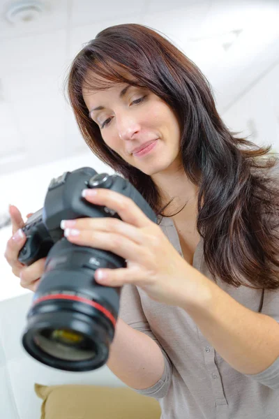 Frau schaut auf Display moderner Slr-Kamera — Stockfoto