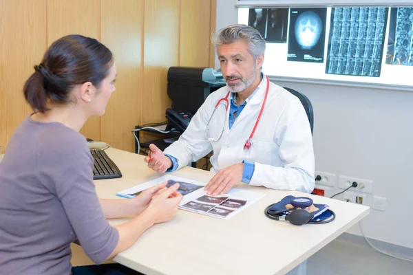 Medico discutendo i risultati dei raggi X con il paziente — Foto Stock