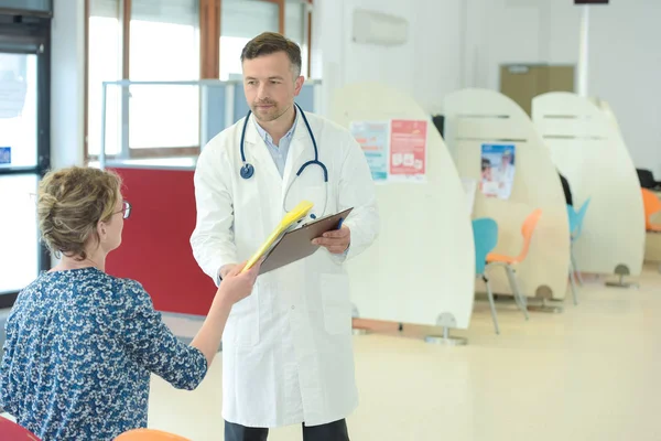 Лікар розмовляє з пацієнтом у вестибюлі — стокове фото