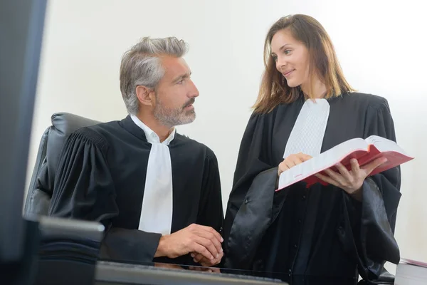 Judges looking at red book — Stock Photo, Image