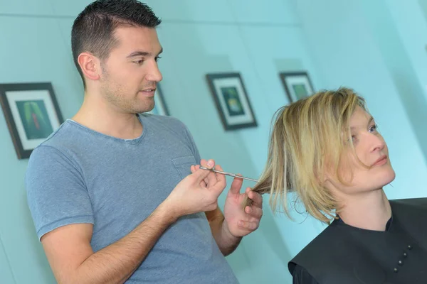 Male hairdresser makes the cut for blonde girl — Stock Photo, Image