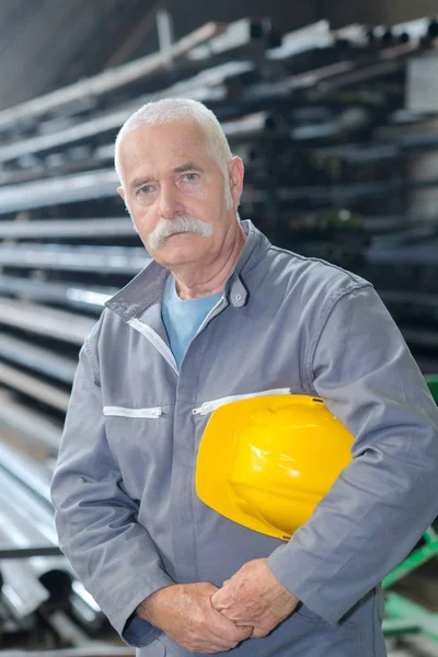 Bauarbeiter mit Helm am Arbeitsplatz in einer Fabrik — Stockfoto