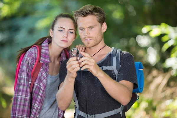 Couple of backpackers looking at compass — Stock Photo, Image