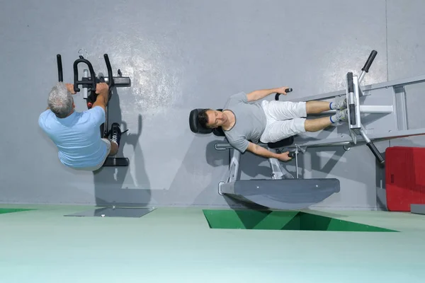 Twee mannen trainen met fitness machine — Stockfoto