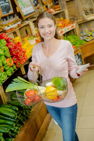 Femme avec panier de fruits et liste — Photo