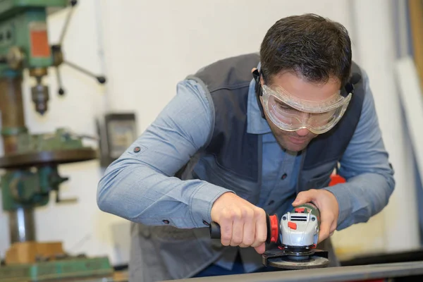 Bricoleur utilisant ponceuse électrique avec des lunettes de sécurité — Photo