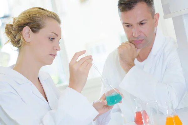 Supervisor watching female lab technician — Stock Photo, Image