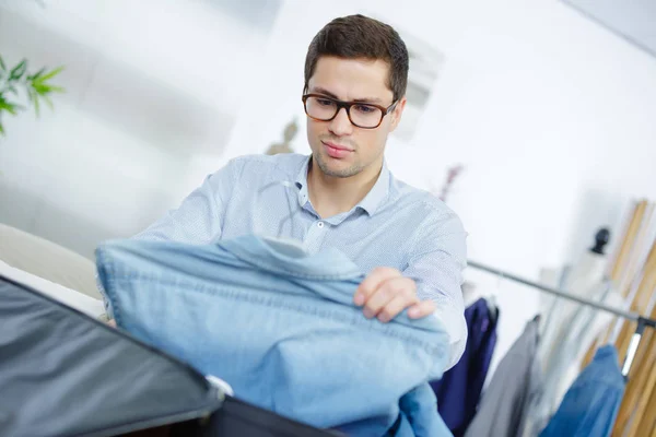 Close up of businessman packing clothes into travel bag — Stock Photo, Image