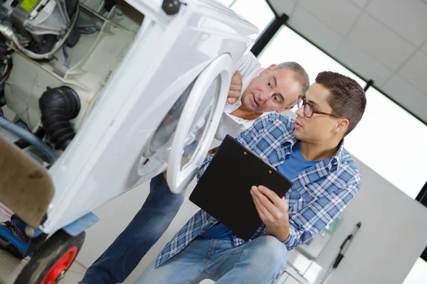 Manitas que buscan problemas técnicos con la lavadora — Foto de Stock