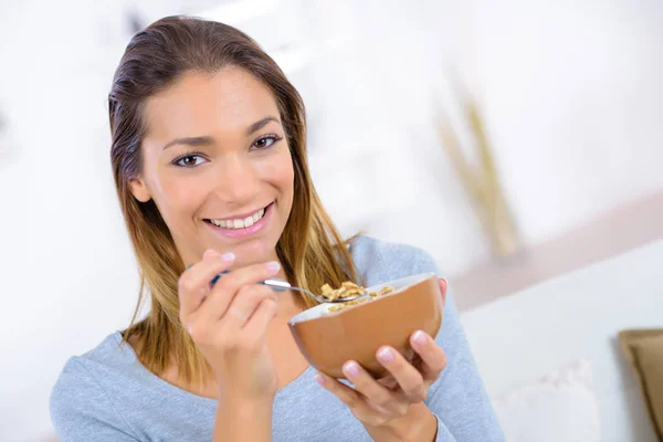 Jovem mulher comendo cereais — Fotografia de Stock