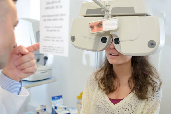 Optometrista examinando paciente femenina con messbrille en clínica oftalmológica — Foto de Stock
