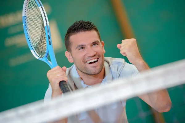 Чоловік святкує перемогу на тенісному корті — стокове фото