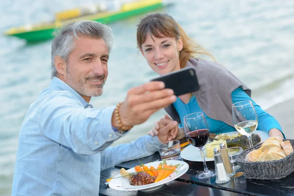 Couple à manger prenant photo autoportrait — Photo