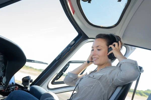 Mulher feliz colocando fones de ouvido no helicóptero — Fotografia de Stock