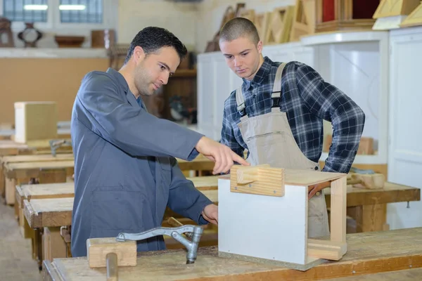 Tischlerlehrling hört Lehrer in Werkstatt zu — Stockfoto