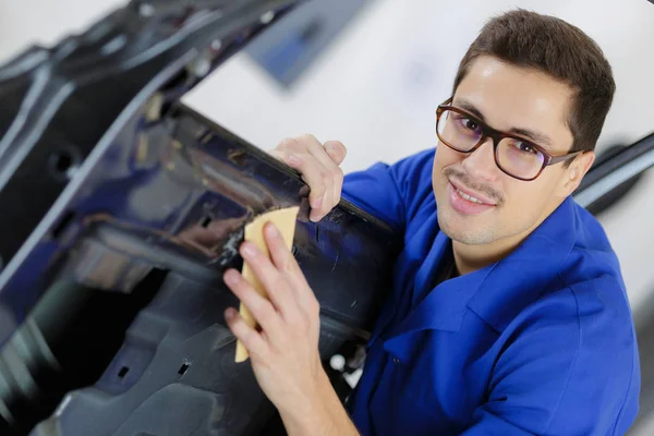 Junger Servicemechaniker reinigt Autotür — Stockfoto