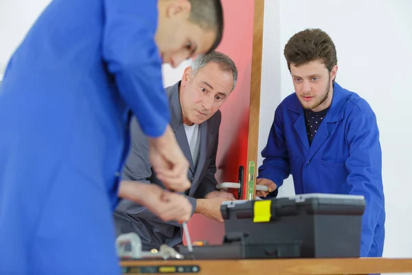 Apprentis apprenant à adapter le mécanisme de porte — Photo