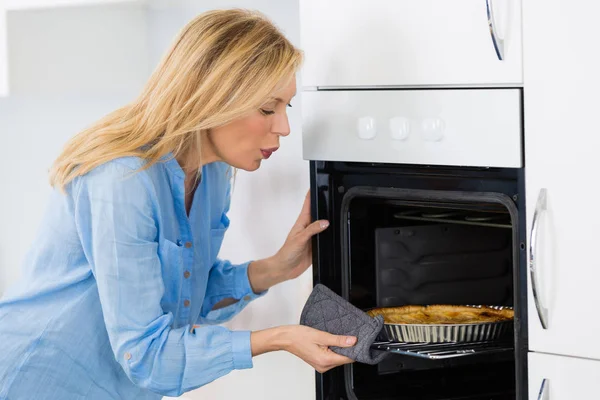 Mujer cocinar pastel en el horno en casa cocina —  Fotos de Stock