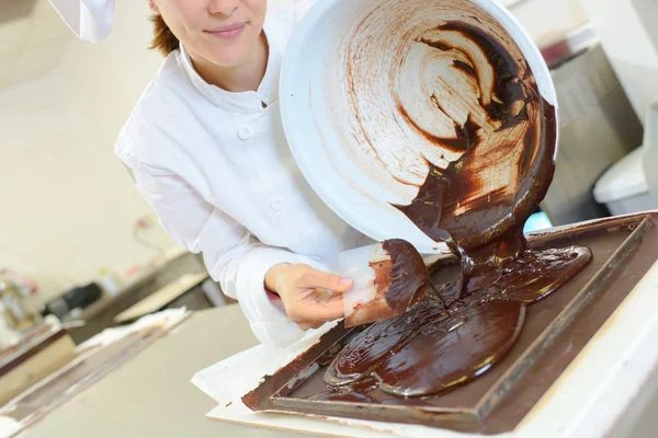 Chocolate derretido derramado na bandeja — Fotografia de Stock