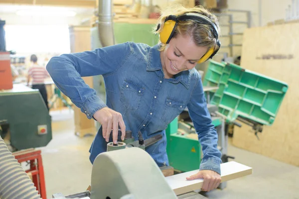 Carpinteiro feminino usando lixadeira elétrica para madeira — Fotografia de Stock
