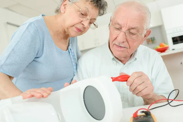 Älteres Ehepaar repariert Kaffeemaschine — Stockfoto