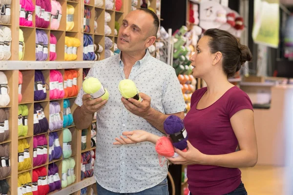Joven pareja elegir lana en textil tienda —  Fotos de Stock