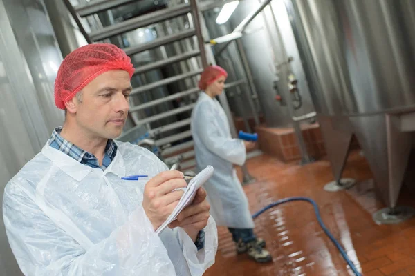 factory worker cleaning floor