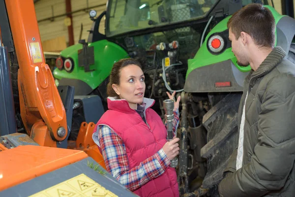 Donna attraente che vende trattore nuovo di zecca al contadino principiante — Foto Stock