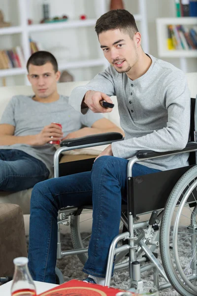 2 vrienden, tv kijken en het drinken van frisdrank een is uitgeschakeld — Stockfoto