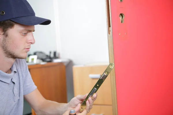 Hombre arreglando una puerta rota — Foto de Stock