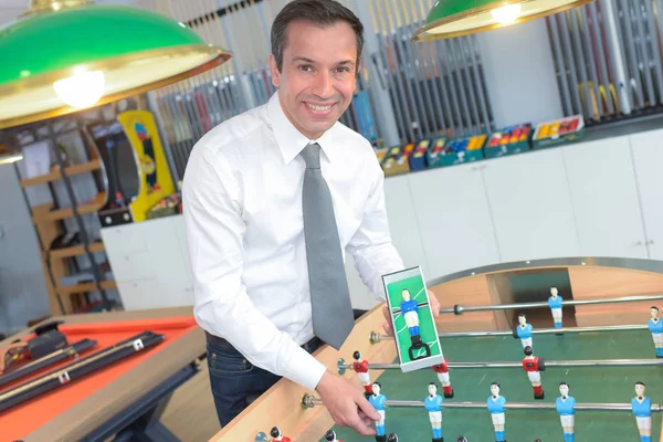 Homem bonito jogando futebol de mesa — Fotografia de Stock