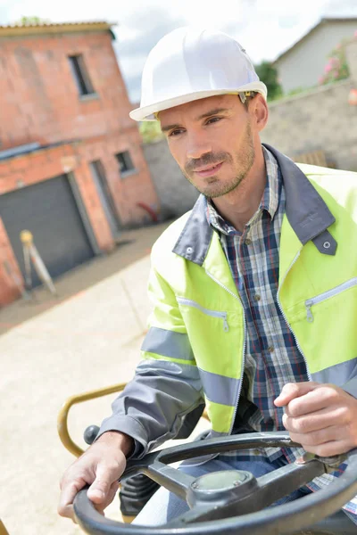 Un trabajador de la construcción que conduce la máquina en el sitio — Foto de Stock