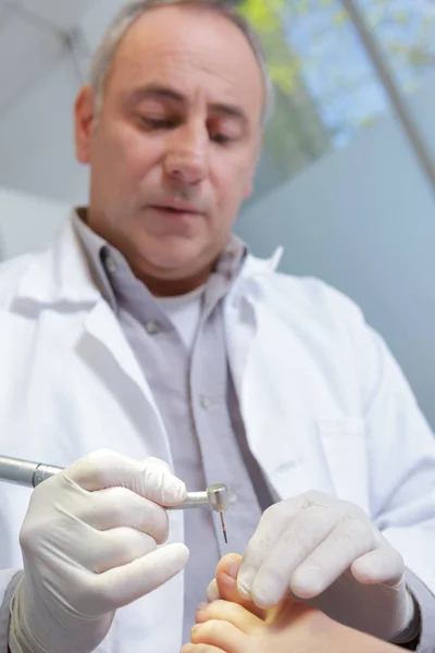 Chiropodist using drill on toe — Stock Photo, Image