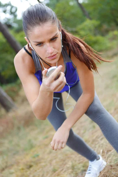 Kobiece runner patrząc na jej sportowy zegarek — Zdjęcie stockowe