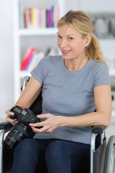 Mulher em cadeira de rodas usando uma câmera — Fotografia de Stock